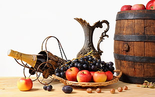 assorted fruits with wine bottle near barrel
