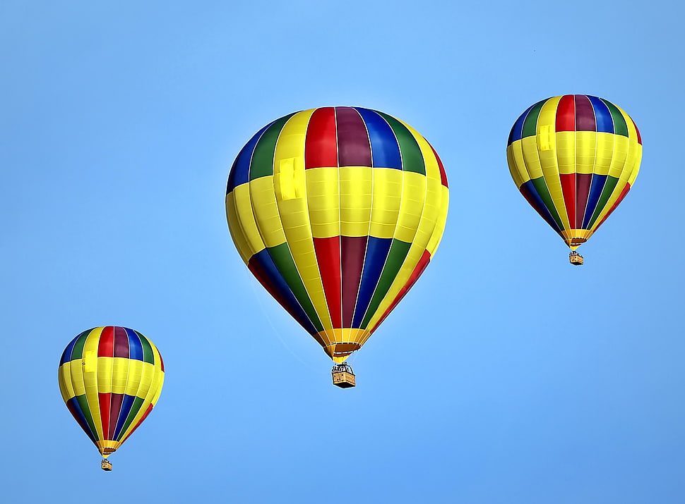 three yellow red and blue hot air balloons under blue sky HD wallpaper