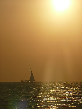 sailing ship on body of water during sunset