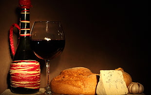 still-life photograph on wine near glass beside breads
