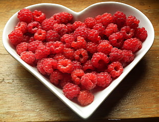 Raspberry on white ceramic heart shape bowl HD wallpaper