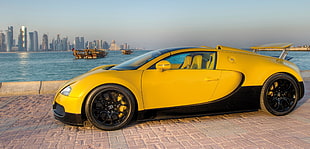 yellow sports coupe parked beside body of water during daytime