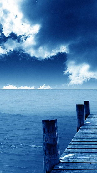 blue cloudy sky under blue body of water HD wallpaper