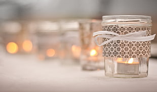 selective focus photography of tealight candle with glass holder