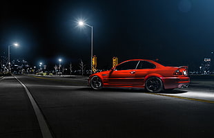 red coupe on gray asphalt road at night time