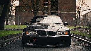 black BMW car near brown building during daytime