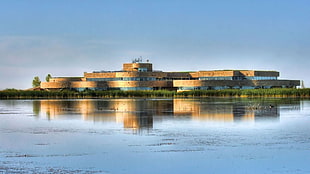 photo of brown and blue building surrounded by body of water