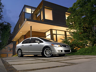 photo of gray sedan beside gray concrete storey house
