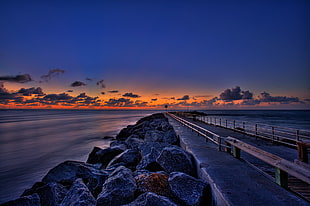photo of rock formation near body of water during sunset, jupiter inlet