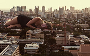 photo manipulation of woman laying near city buildings