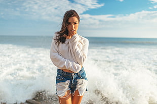 time lapse photography of woman wearing white sweater beside seashore