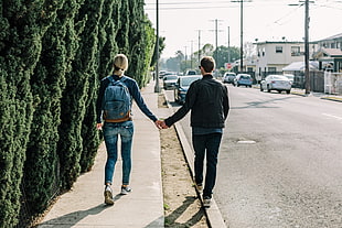 man and woman holding hands while walking HD wallpaper