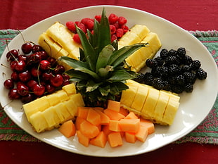 sliced pineapples, Blueberries, and red cherries