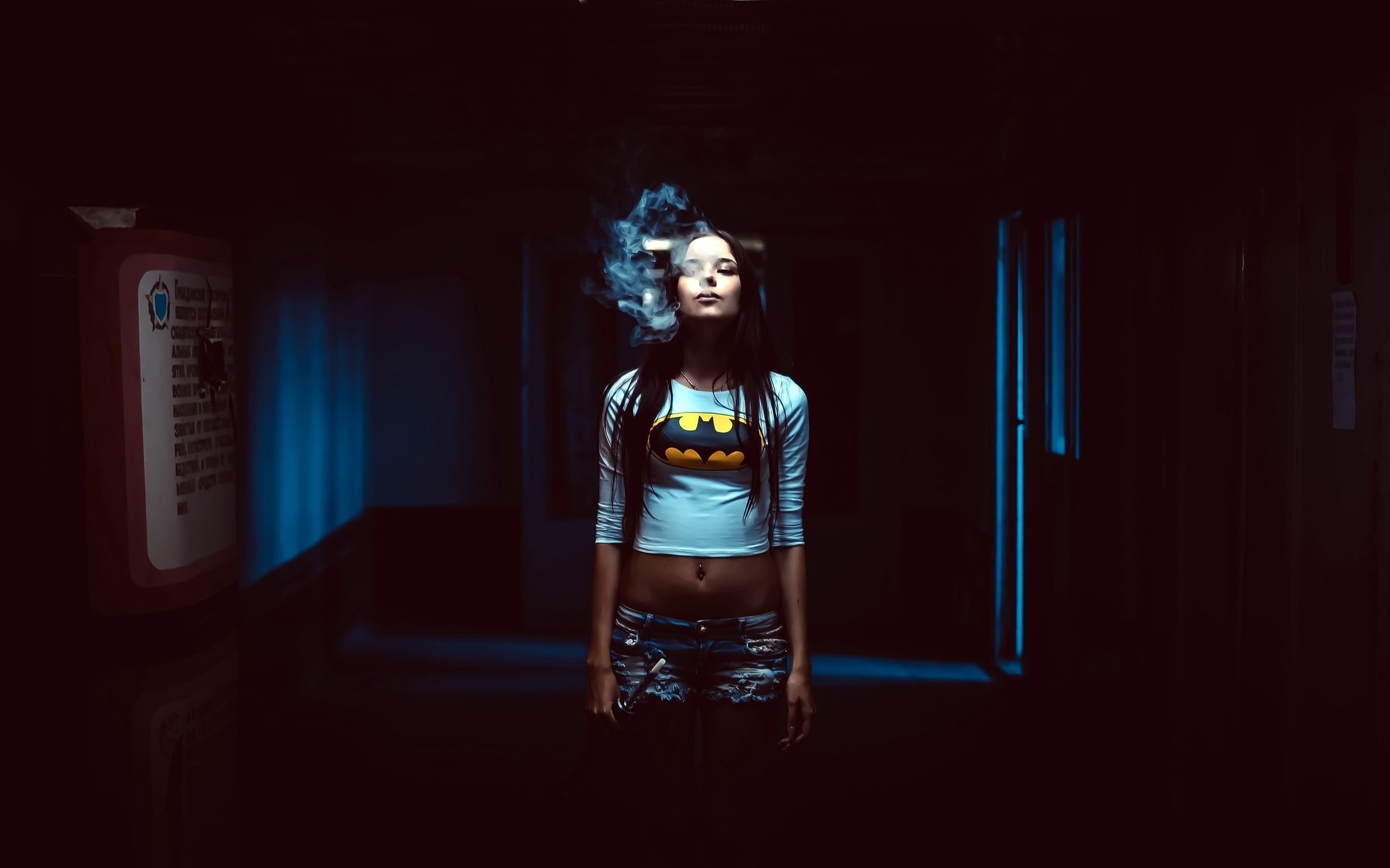 woman in white Batman portrait long-sleeved crop top while smoking