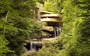 brown concrete building surrounded with trees and river
