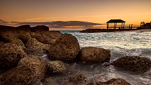 landscape photography of a gazebo near seashore during golden hour HD wallpaper