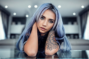 shallow focus photography of a woman with long blue hair and black tattoo on her left arm