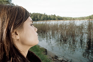 brown-haired woman near lake during daytime