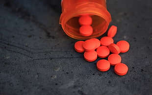 red plastic prescription bottle with red tablets HD wallpaper