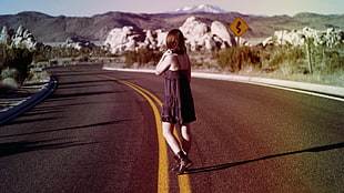 woman standing on gray concrete pavement during daytime