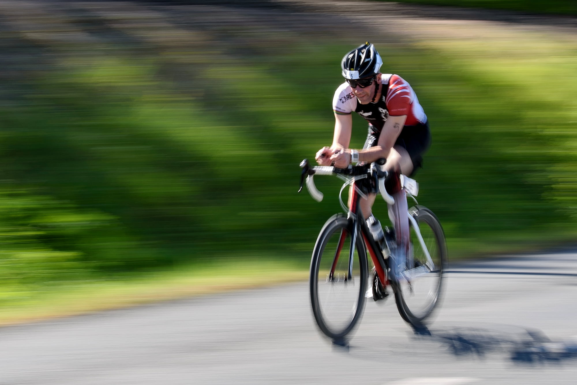 man on road bike beside green grass at dyatime