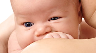 newborn photography of infant on person's arm