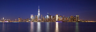cityscape of lighted up city near calm body of water, manhattan HD wallpaper