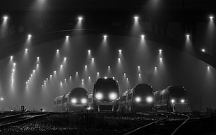grayscale photography of four trains, night, lights, train station, railway