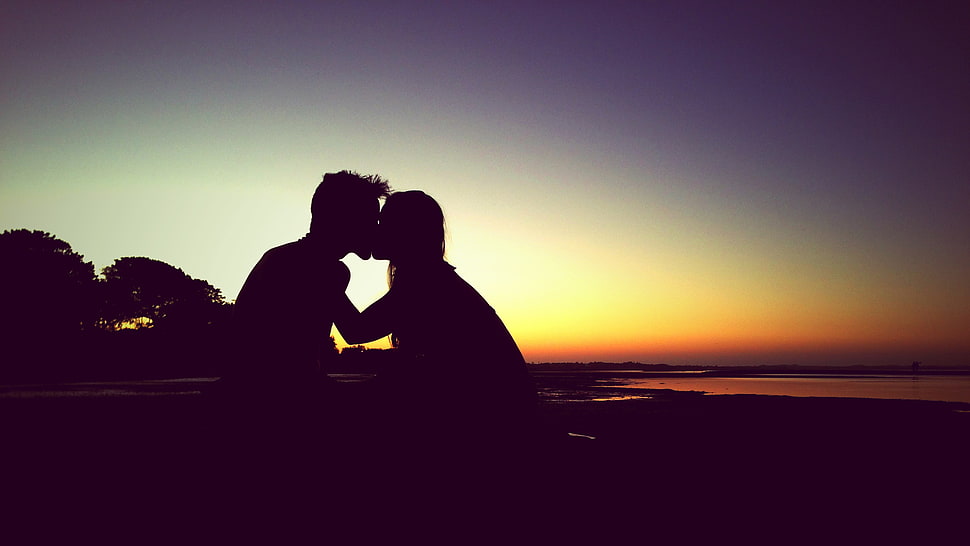silhouette of man and woman kissing during sunset HD wallpaper