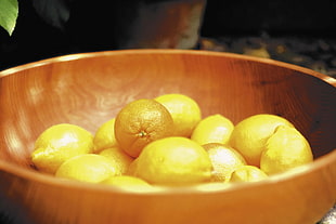 lemon fruit on brown wooden bowl