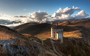 white and brown concrete building at the middle of the mountain during daytime