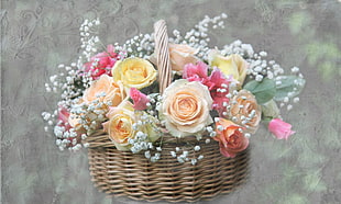 white, yellow, and pink Rose flowers with brown wicker basket
