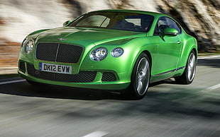 green Bentley Continental GT speeding on road