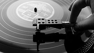 grayscale photograph of person holding vinyl player