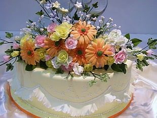 orange and pink flowers table decor on white cake