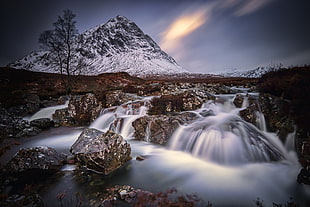 flowing water on stream with mountain covered with snow background HD wallpaper