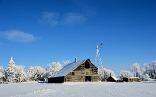 brown wooden barn near the white metal sattelite tower in winter season photo in daytime
