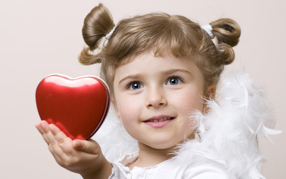 girl in cherub costume holding red heart shaped case HD wallpaper