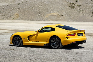 yellow coupe on gray sand HD wallpaper