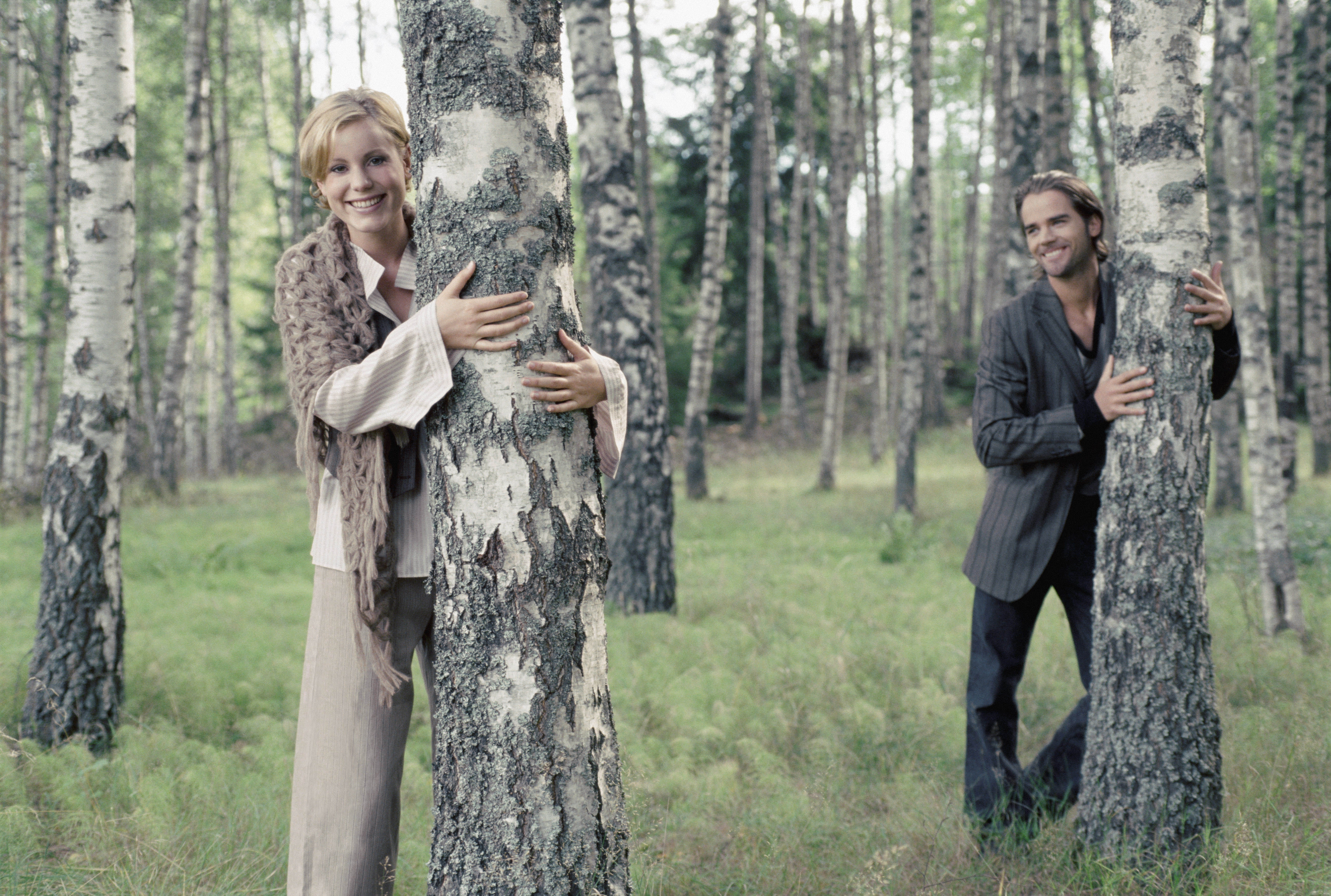 man and woman hugging oak tree during daytime