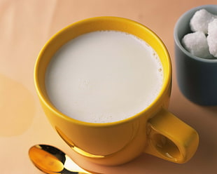 milk on yellow ceramic mug