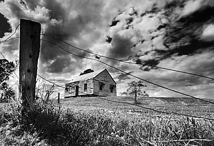 gray scale low angle view of brown house under clouds