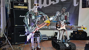 two robot playing guitar on stage HD wallpaper