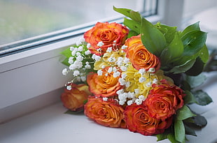 orange, white, and red flower bouquet on white surface