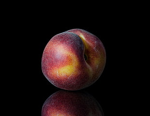 maroon and yellow peach fruit on black table