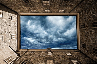 4 concrete buildings on top with gloomy clouds photo