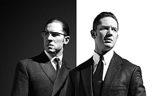 grayscale photography of two men wearing suit jackets against black and white background