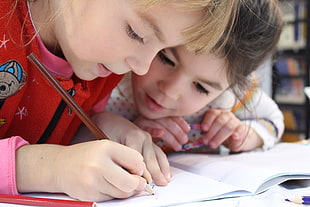 two child writing on paper