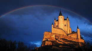 gray castle under rainbow