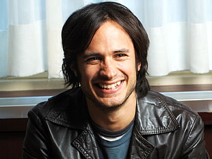 smiling man wearing black leather top